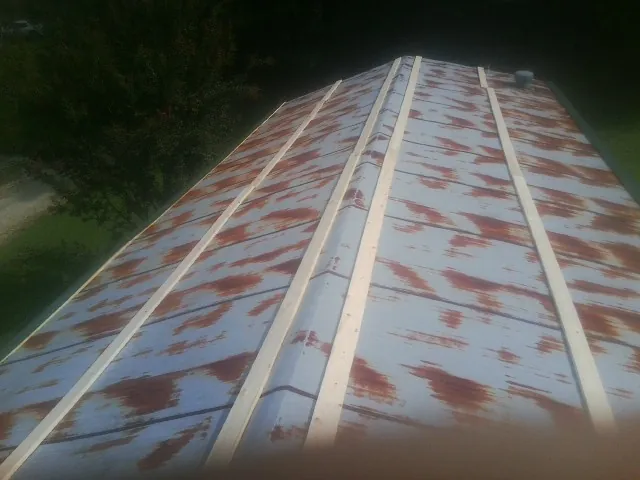 Rusted metal roof panels with new wood purlins before replacement — Storm Damage Roof Repair in Mesick by Roofing Brothers